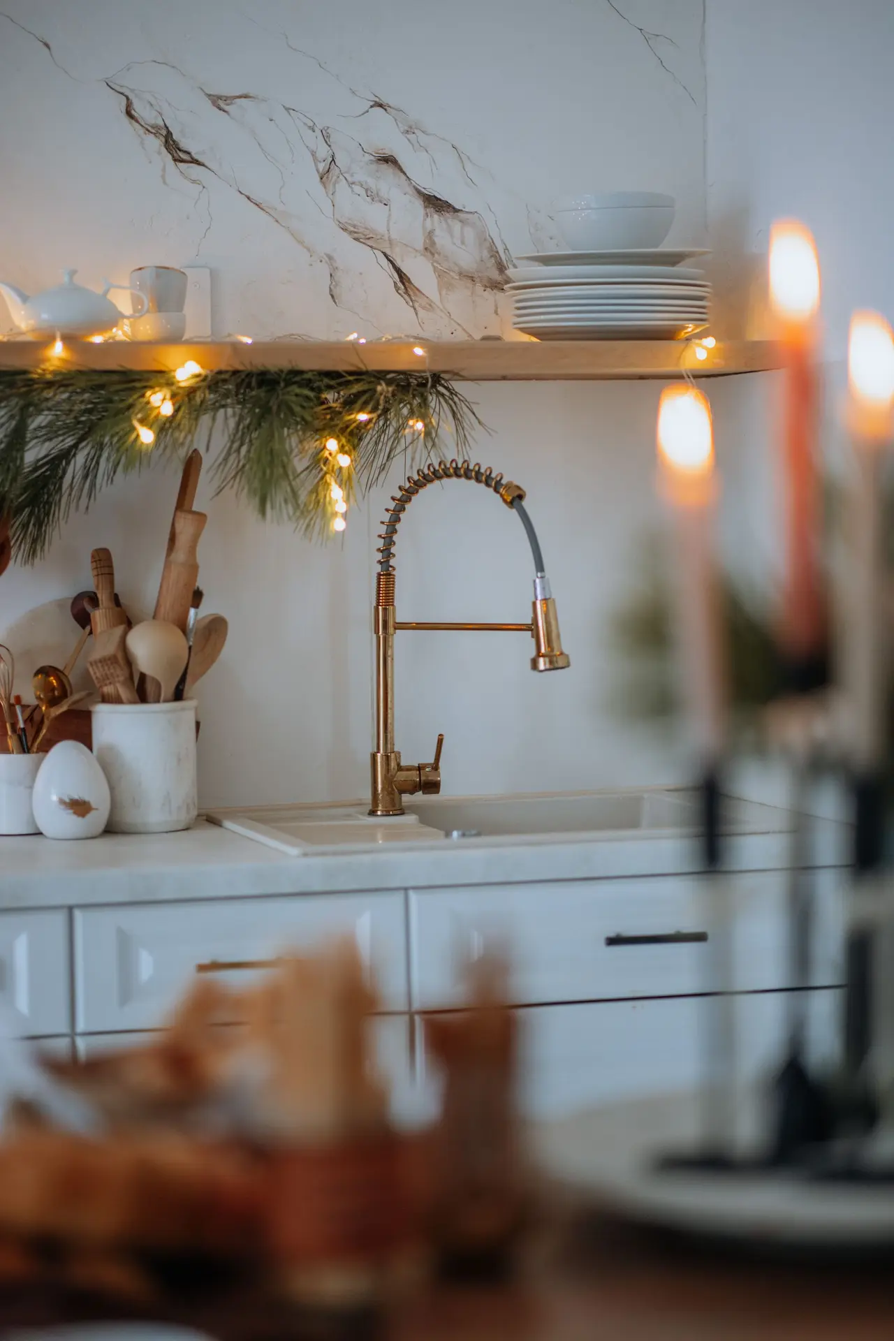Free Warm kitchen setting with holiday decorations and elegant tableware.