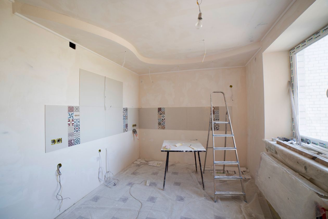 Spacious kitchen under renovation with a ladder and tools